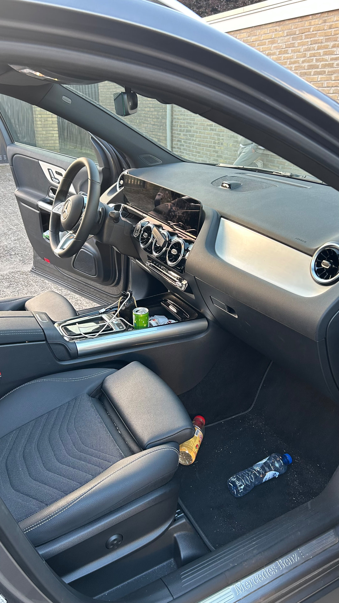 Dashboard en bijrijderskant met drankjes en rommel, voor de reiniging